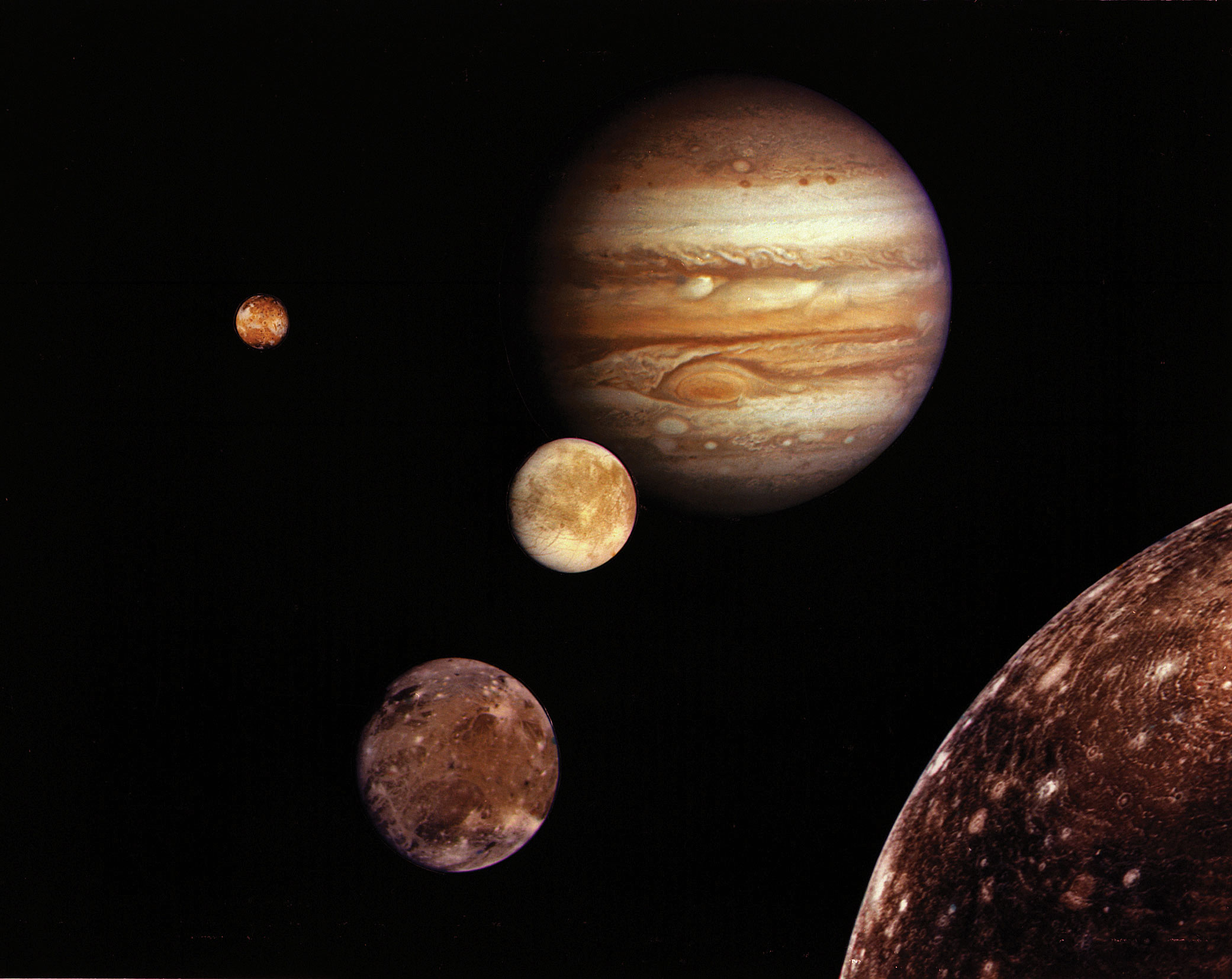 Jupiter and its four planet-size moons, called the Galilean satellites, were photographed in early March 1979 by Voyager 1 and assembled into this collage. They are not to scale but are in their relative positions. Startling new discoveries on the Galilean moons and the planet Jupiter made by Voyager l factored into a new mission design for Voyager 2. Reddish Io (upper left) is nearest Jupiter; then Europa (center); Ganymede and Callisto (lower right). Credit: NASA/JPL
