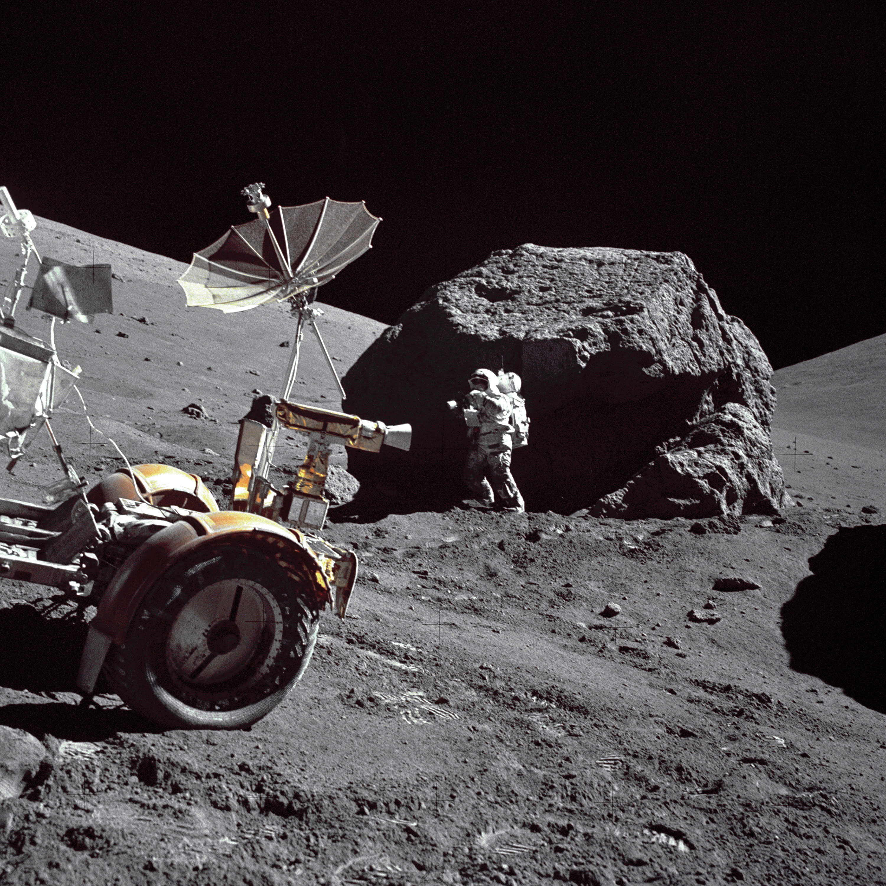 Harrison Schmitt stands next to a huge, split boulder on the sloping base of North Massif during EVA-3 at the Taurus-Littrow landing site. Credit: NASA