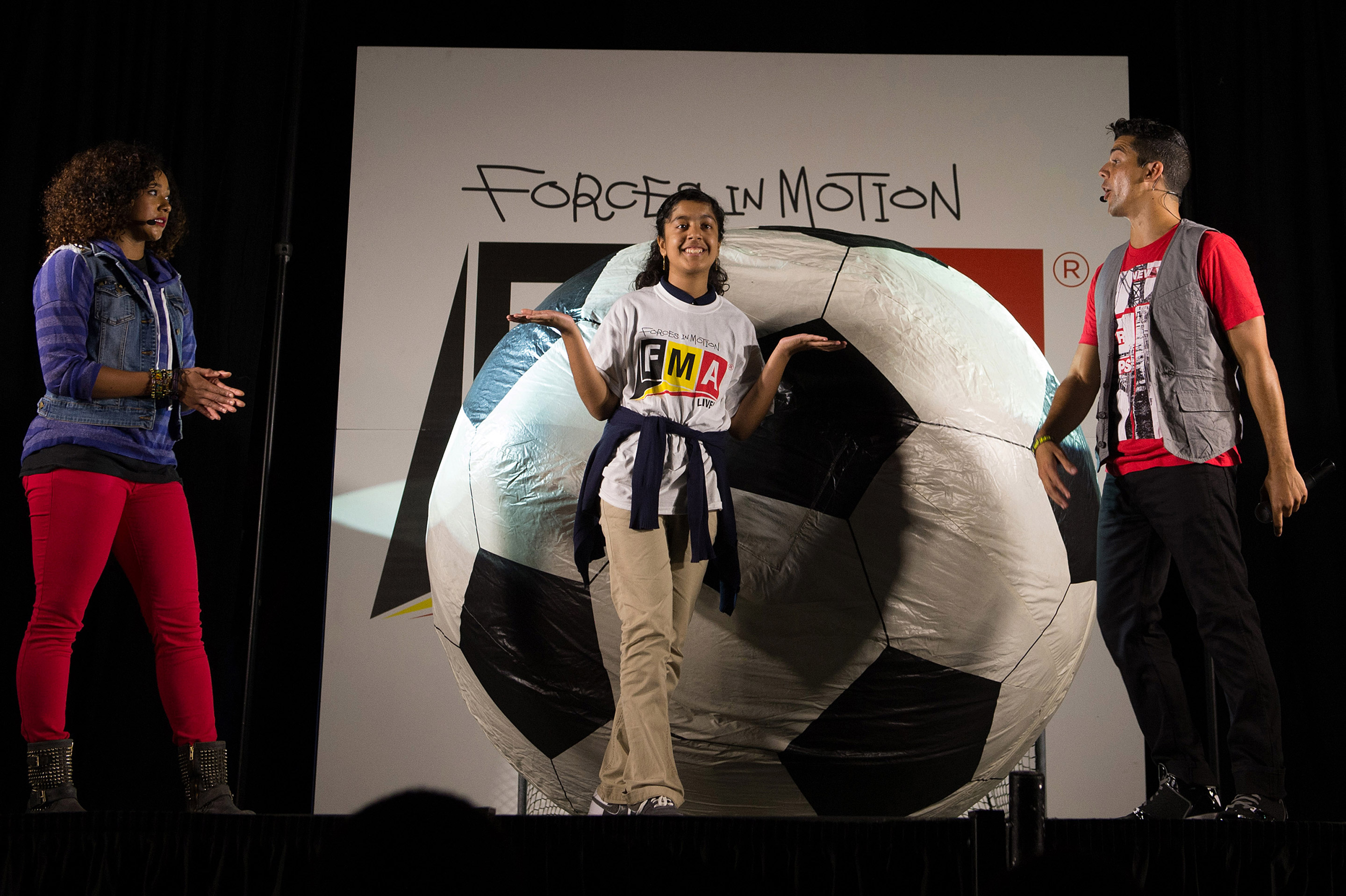 With the help of a student participant, “FMA Live!” crew members explain Newton’s second law of motion during the same performance. “FMA Live!” is a program sponsored by NASA and Honeywell that teaches Newton’s three laws of motion mixed with dance and music. Image: NASA/Jay Westcott