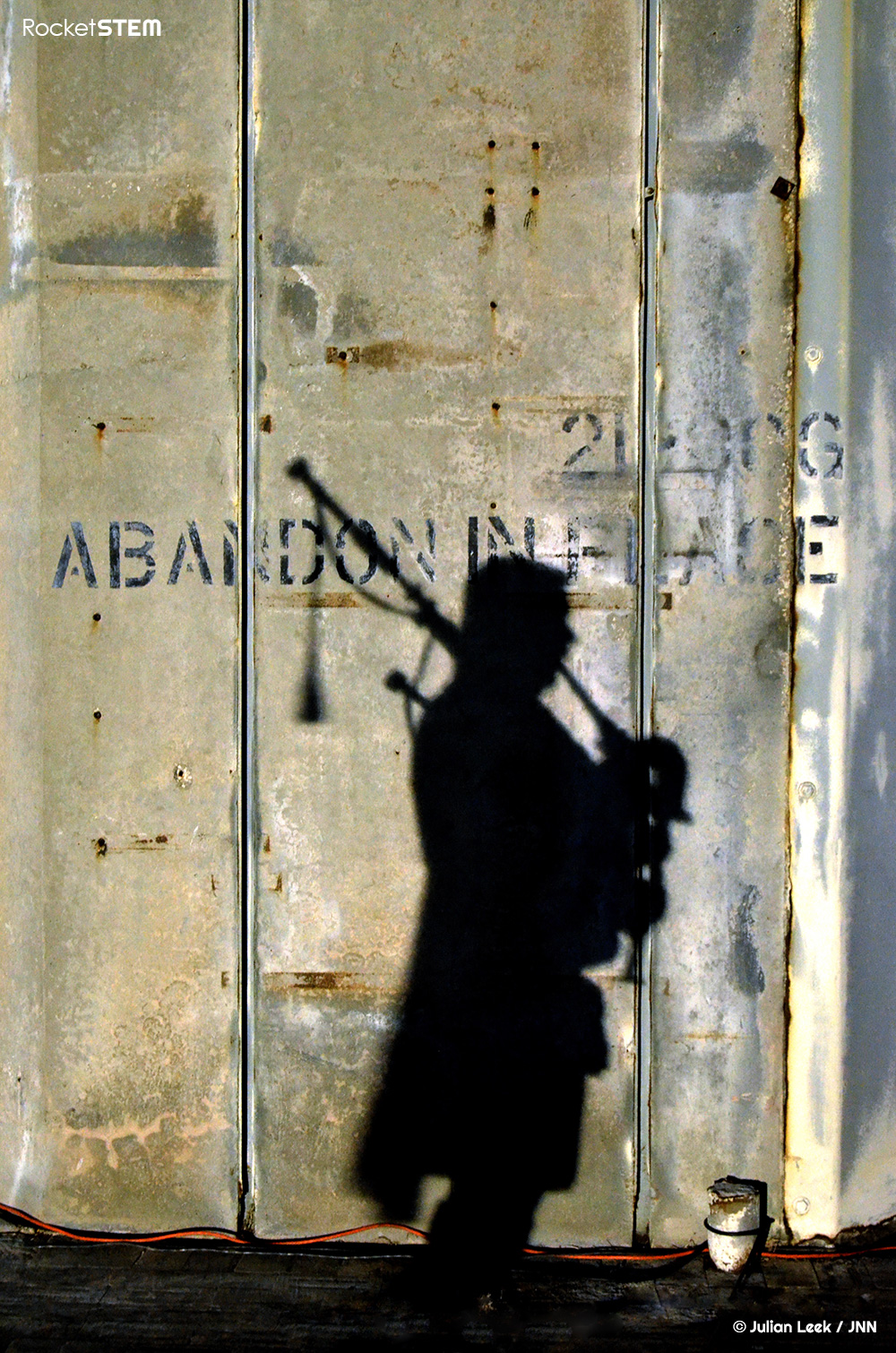 Silohuette of a bagpiper against the LC-34 concrete launch pedestal. Photo: Julian Leek/JNN