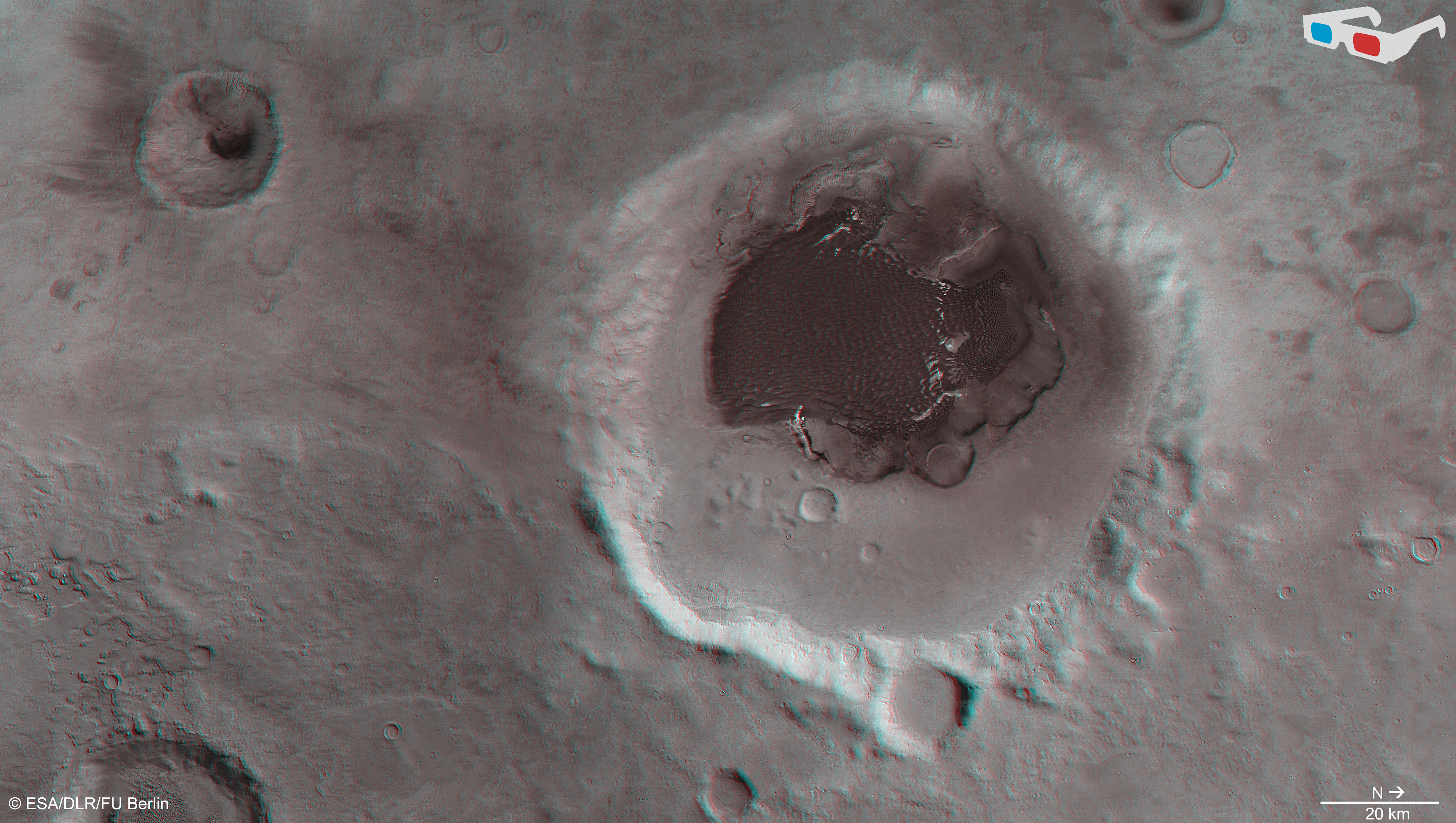 Data from the nadir channel and one stereo channel of the High Resolution Stereo Camera on Mars Express have been combined to produce this anaglyph 3D image, which can be viewed using stereoscopic glasses with red–green or red–blue filters. The image focuses on Rabe crater and its intricate dune field, material that has been shaped by prevailing winds. The image was created using data acquired with the High Resolution Stereo Camera on Mars Express on 7 December 2005 (orbit 2441) and 9 January 2014 (orbit 12736). Credit: ESA/DLR/FU Berlin