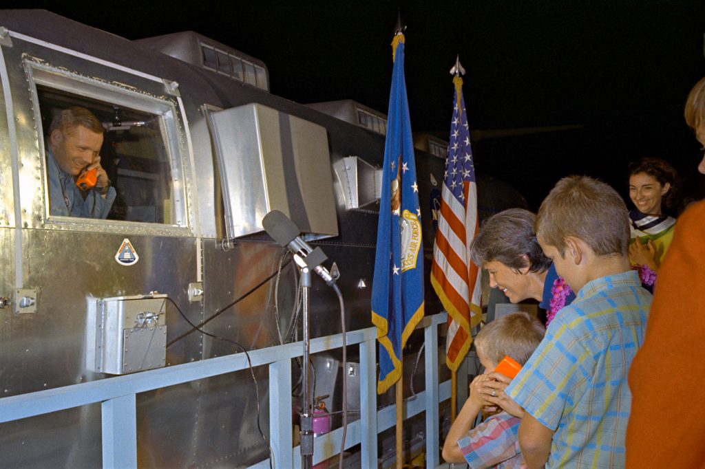The Apollo 11 crewmen, still under a 21-day quarantine, are greeted by their family at Ellington Air Force Base after a flight aboard a C141 transport from Hawaii.