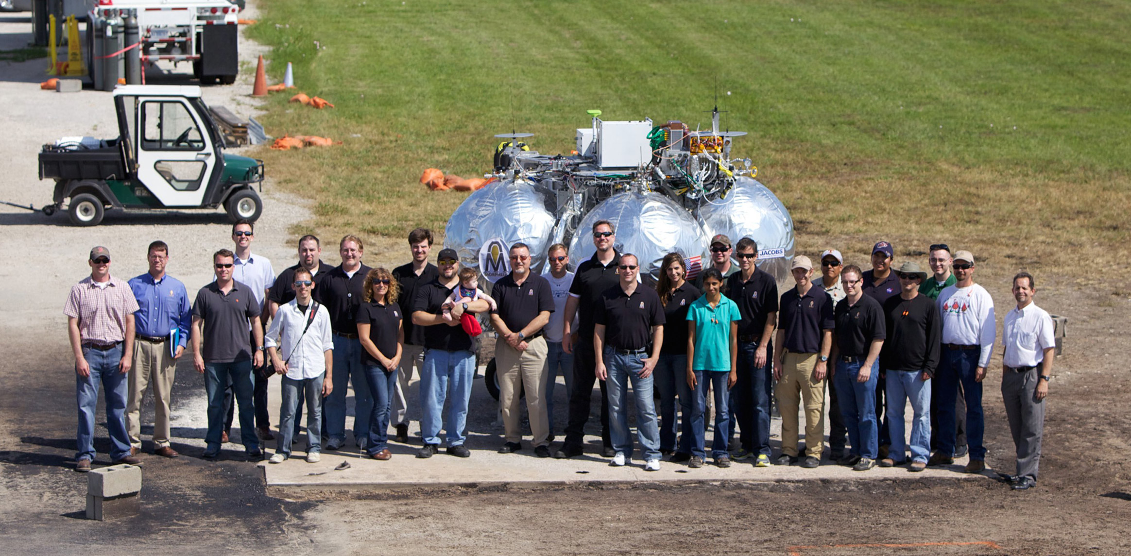 Members of the Project Morpheus team pose for a group photo during the 11th tether test of the prototype lander which took place in 2012 at the Johnson Space Center VTB Flight Complex. Credit: NASA/Joe Bibby
