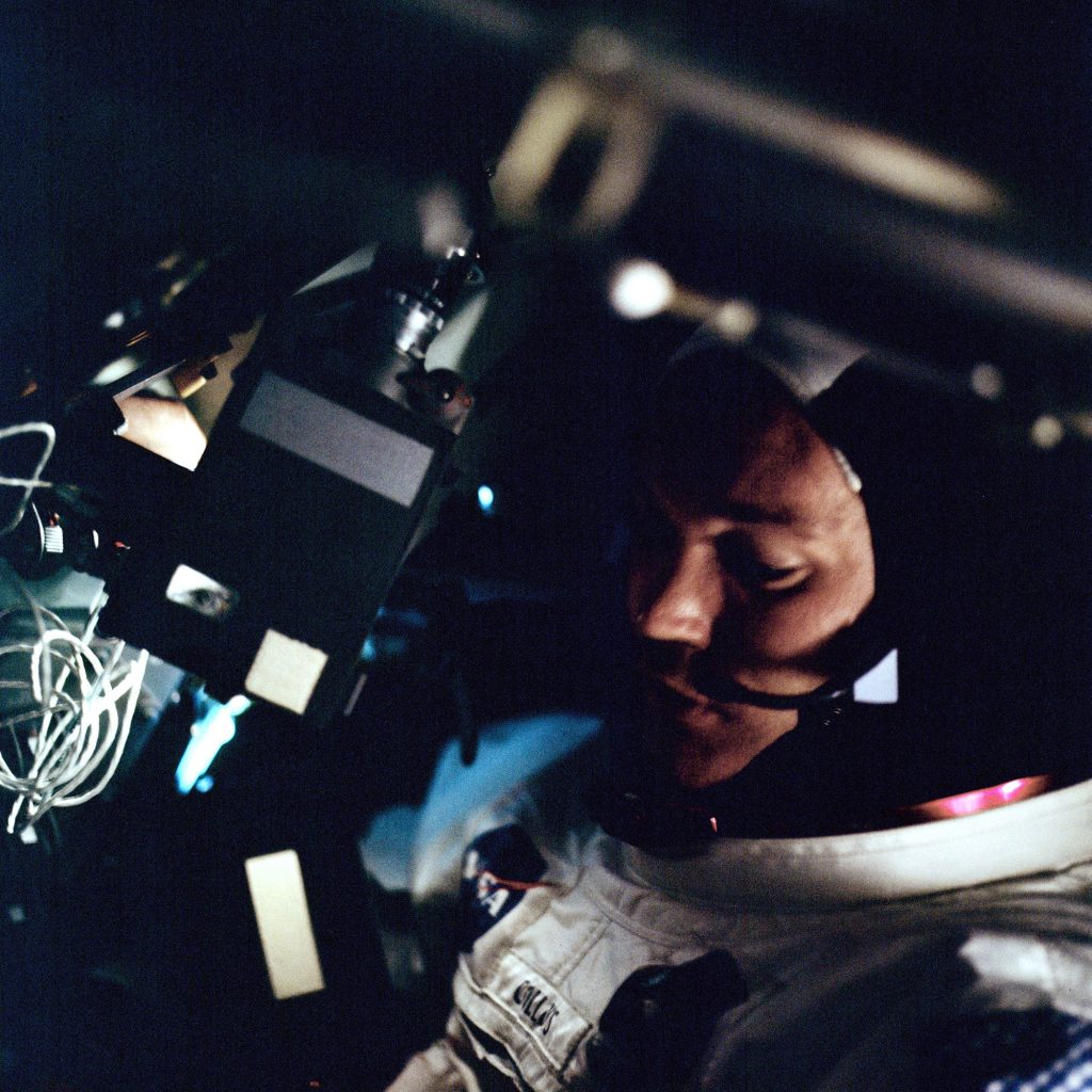 Michael Collins aboard the Apollo 11 spacecraft during the trip to the Moon. As the Command Module Pilot, Collins stayed in orbit around the Moon, while Neil Armstrong and Aldrin descended to the surface and became the first men to walk on the Moon.