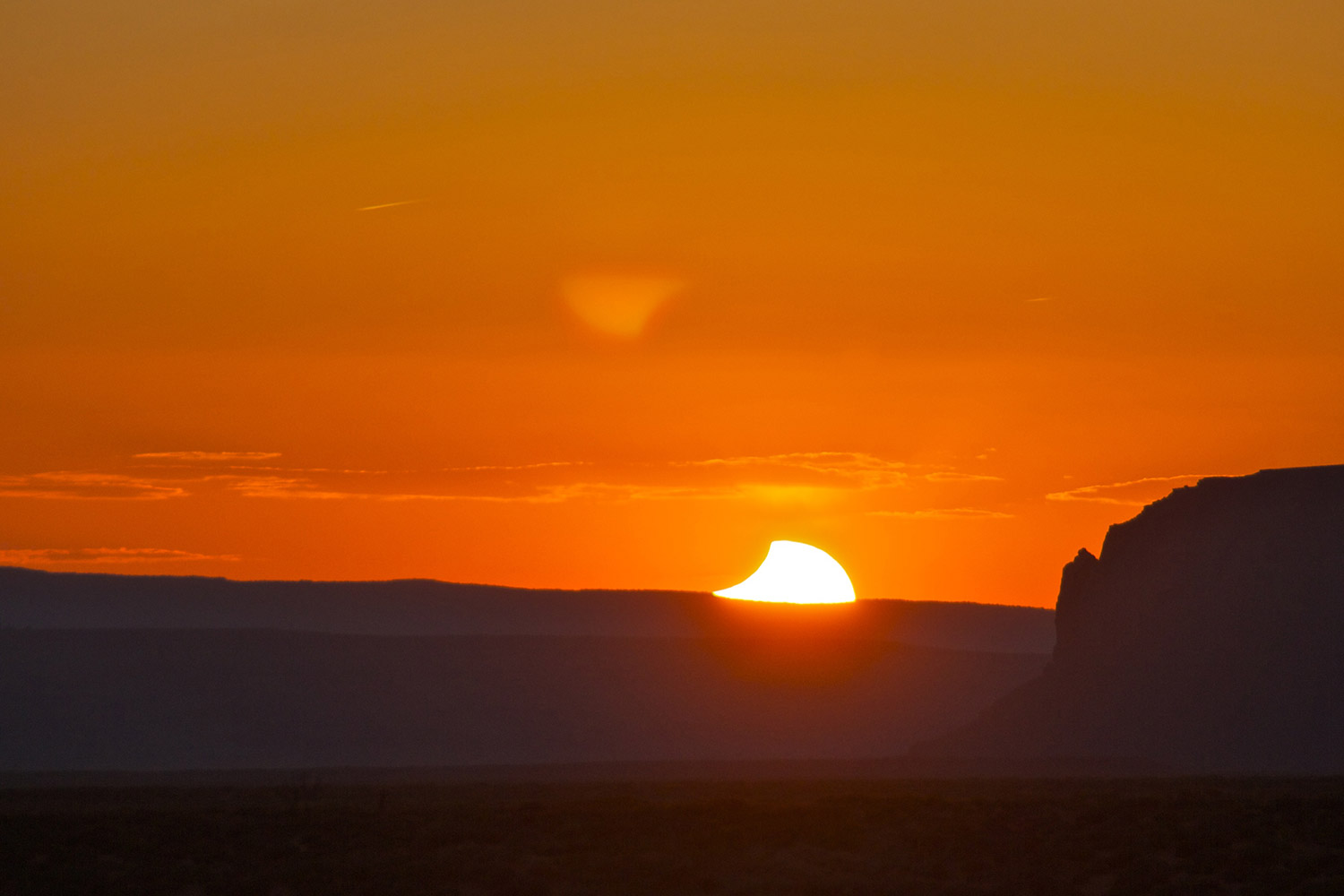 An eclipse of the Sun at sunset over Monument Valley, Utah shows the Moon gradually moving off revealing the surface of the Sun. Credit: Mike Barrett
