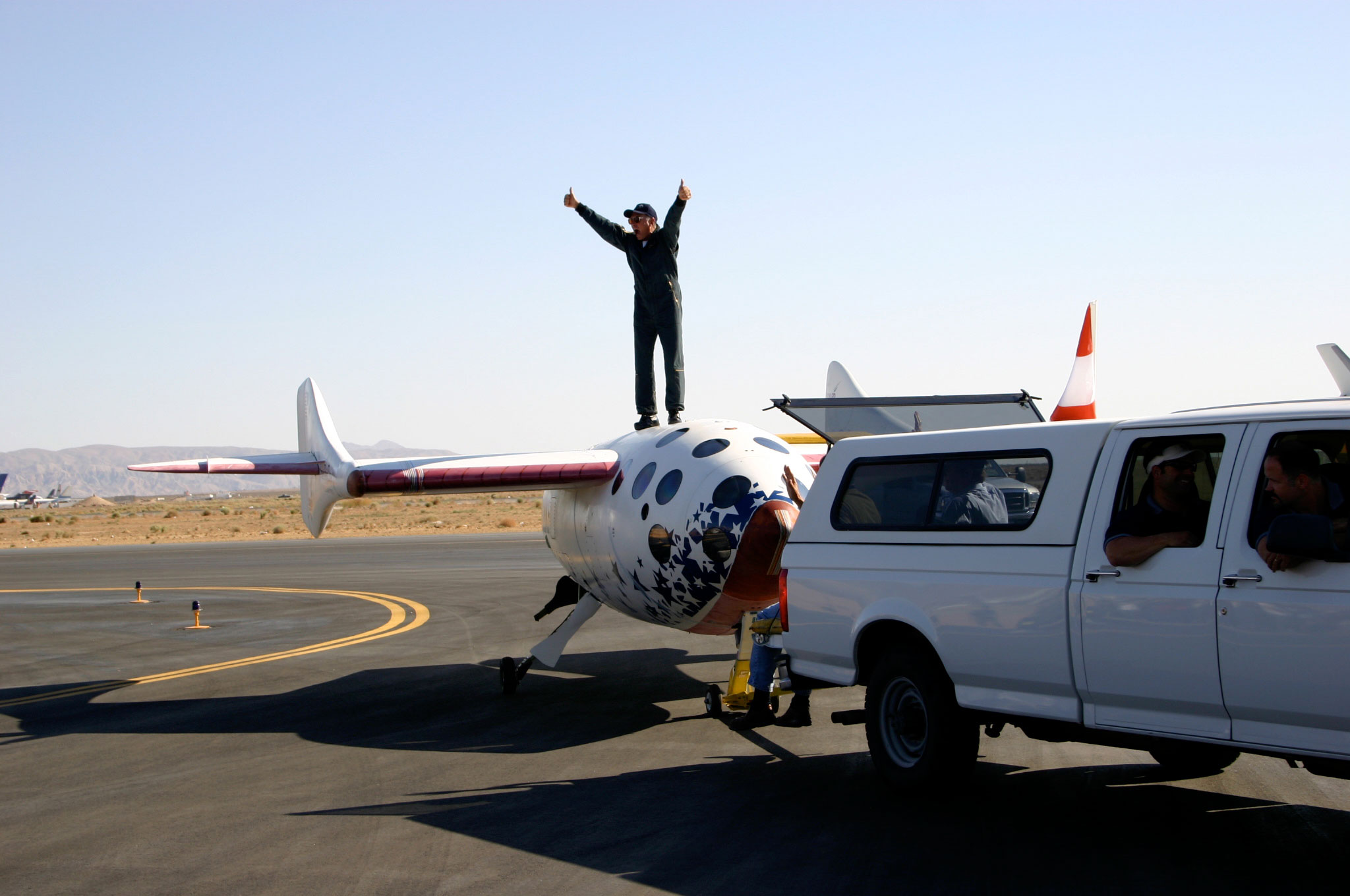 Mike Melvill celebrates atop SpaceShipOne after completion of his first of two trips to outer space aboard the vehicle. Credit: http://www.flickr.com/photos/densaer/