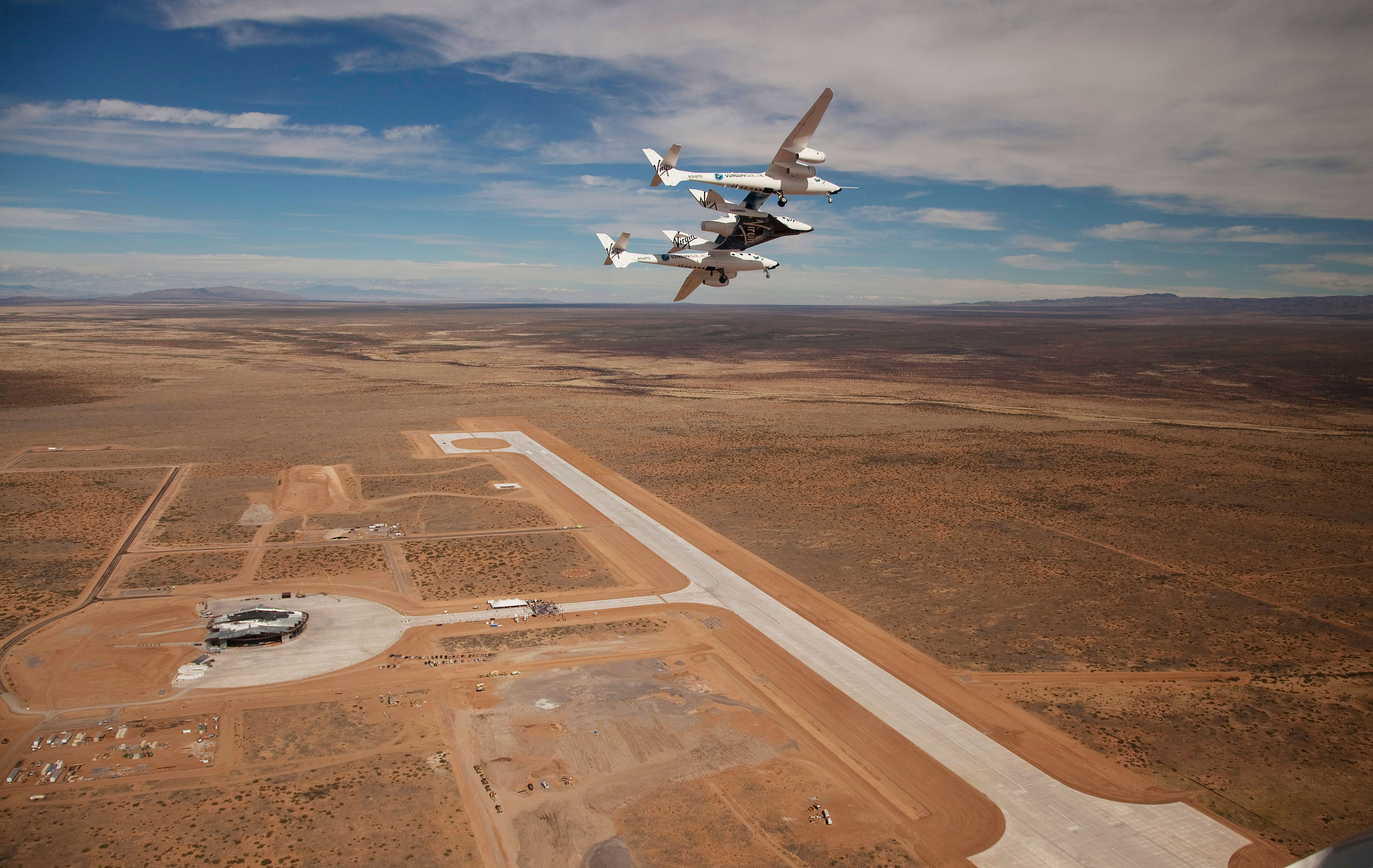 Virgin Galactic’s WhiteKnight2 and SpaceShipTwo soar above the runway at the New Mexico Spaceport. Credit: NMSA/Mark Greenberg