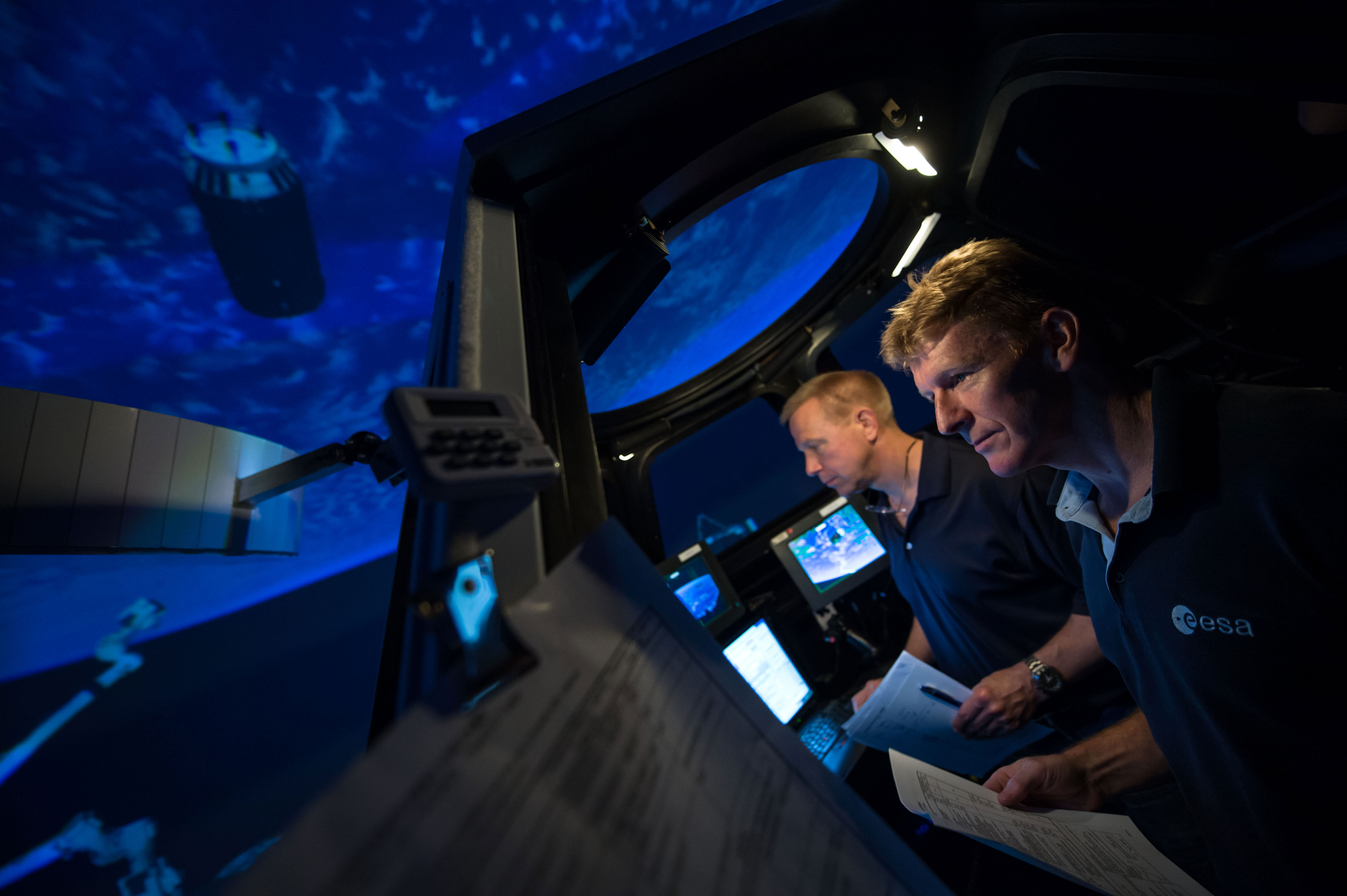 Expedition 47 (Soyuz 45) crew members Tim Kopra and Timothy Peake during training in the SES Alpha Cupola. Credit: NASA/Lauren Harnett