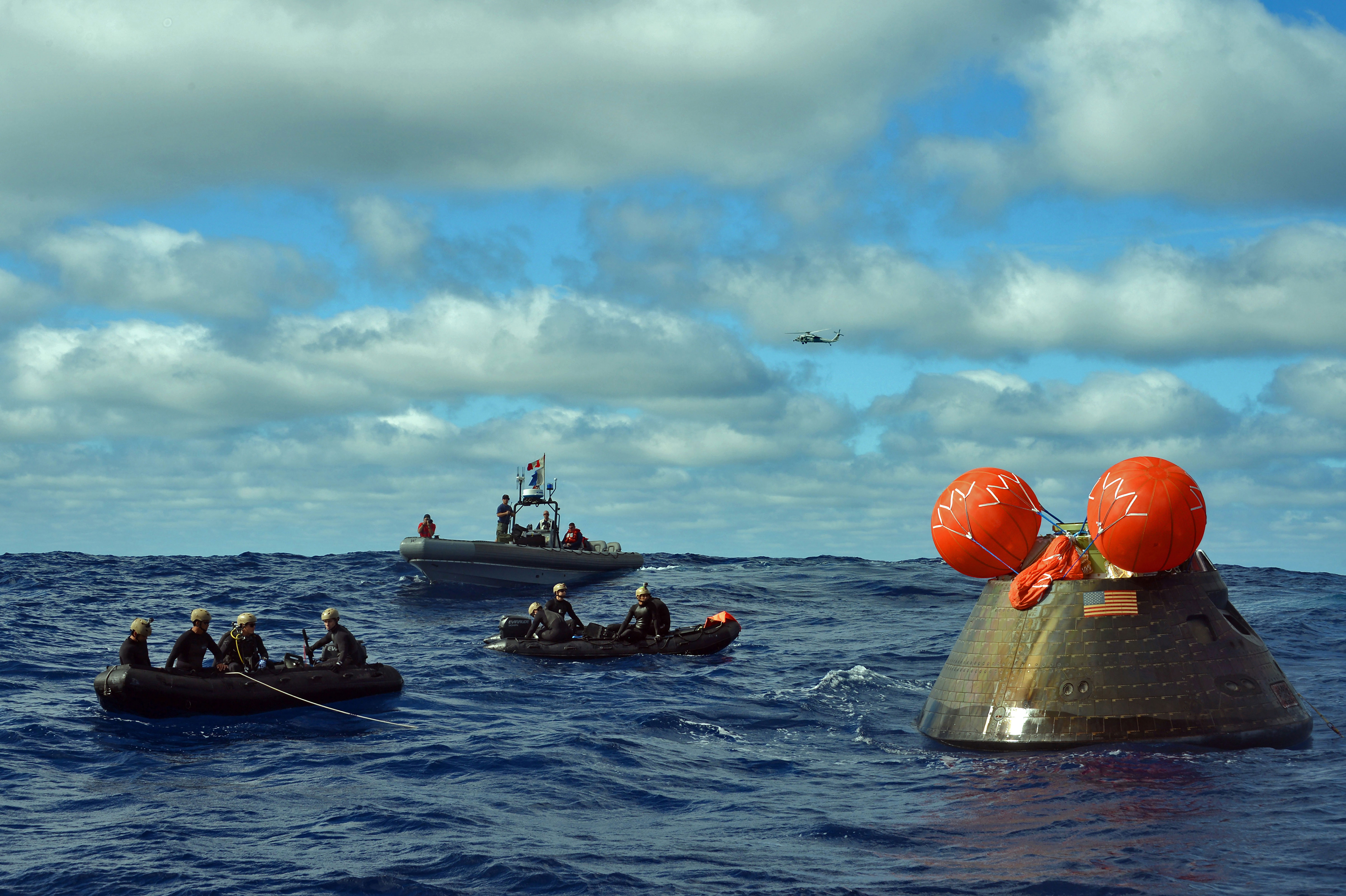 Sailors from the amphibious transport dock, USS Anchorage, and Navy Divers attach a line to the Orion Crew Module. Credit: U.S. Navy/Corey Green