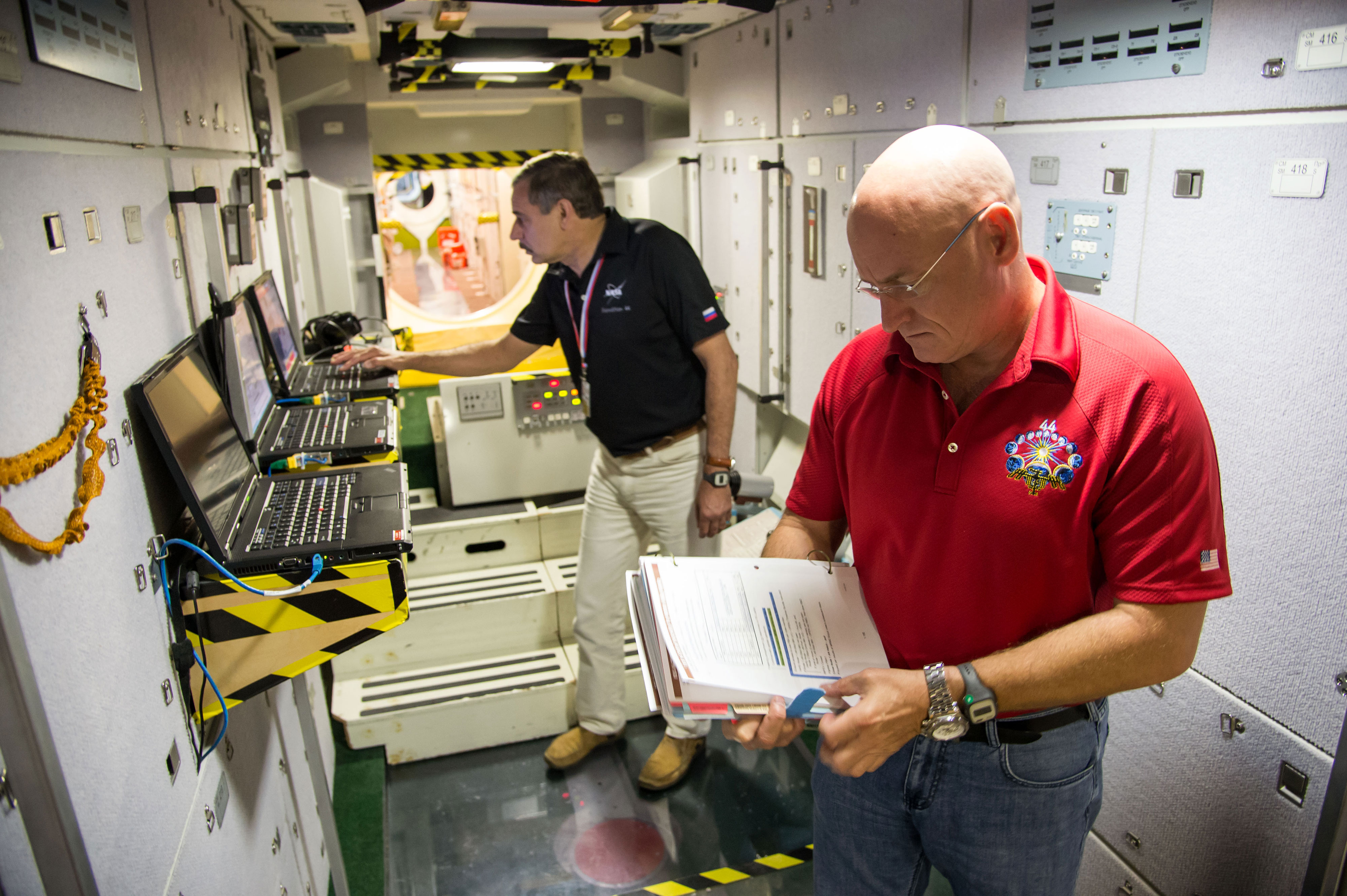 NASA astronaut Scott Kelly (foreground) and Russian cosmonaut Mikhail Kornienko participate in an emergency scenario training session in an International Space Station mock-up/trainer at NASA’s Johnson Space Center in Houston, Texas. Credit: NASA/James Blair