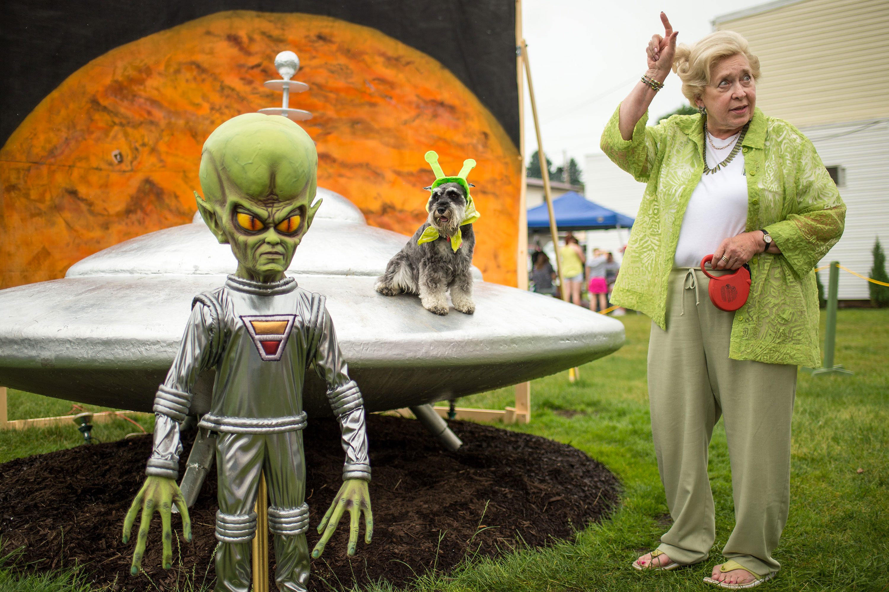 Sue Morris and her dog "Pepper" are seen with a model of a spacecraft and alien used for photos during the Mars New Year's celebration Saturday, June 20, 2015, in Mars, Pennsylvania. Credit: NASA/Bill Ingalls