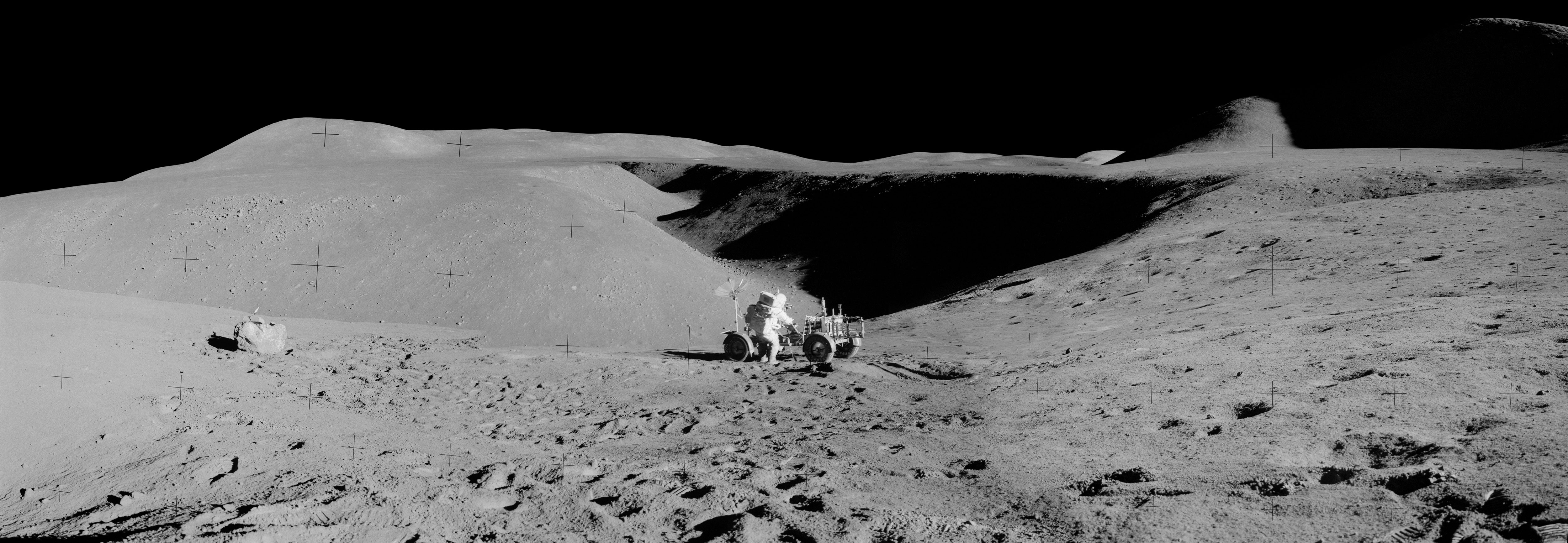 Apollo 15 astronaut Dave Scott and the Lunar Rover with a view up Hadley Rille in the background. Credit: NASA via Retro Space Images