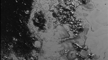 A newly discovered mountain range lies near the southwestern margin of Pluto’s Tombaugh Regio (Tombaugh Region), situated between bright, icy plains and dark, heavily-cratered terrain. This image was acquired by New Horizons from a distance of 48,000 miles (77,000 kilometers) and received on Earth on July 20. Features as small as a half-mile (1 kilometer) across are visible. Credit: NASA/JHUAPL/SWRI