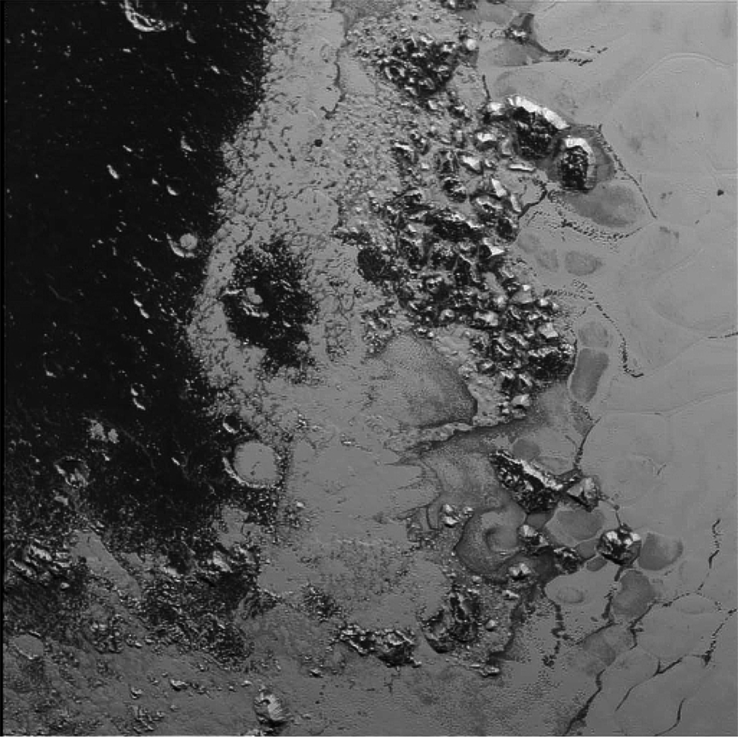 A newly discovered mountain range lies near the southwestern margin of Pluto’s Tombaugh Regio (Tombaugh Region), situated between bright, icy plains and dark, heavily-cratered terrain. This image was acquired by New Horizons from a distance of 48,000 miles (77,000 kilometers) and received on Earth on July 20. Features as small as a half-mile (1 kilometer) across are visible. Credit: NASA/JHUAPL/SWRI
