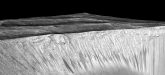 Dark narrow streaks called recurring slope lineae emanating out of the walls of Garni crater on Mars. The dark streaks here are up to few hundred meters in length. They are hypothesized to be formed by flow of briny liquid water on Mars. Credit: NASA/JPL/University of Arizona