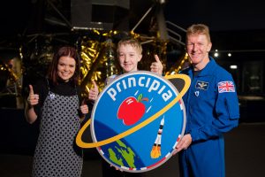 BBC presenter Lindsay Russel, logo designer Troy and Tim Peake with the Principia mission logo. The BBC’s Blue Peter programme asked schoolchildren to design a mission patch for Tim and received more than 3000 entries. Credit: ESA