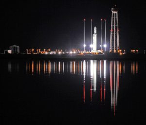 An Antares rocket stands erect, reflecting off the calm waters the night before its first night launch from NASA’s Wallops Flight Facility, VA. Credit: Ken Kremer